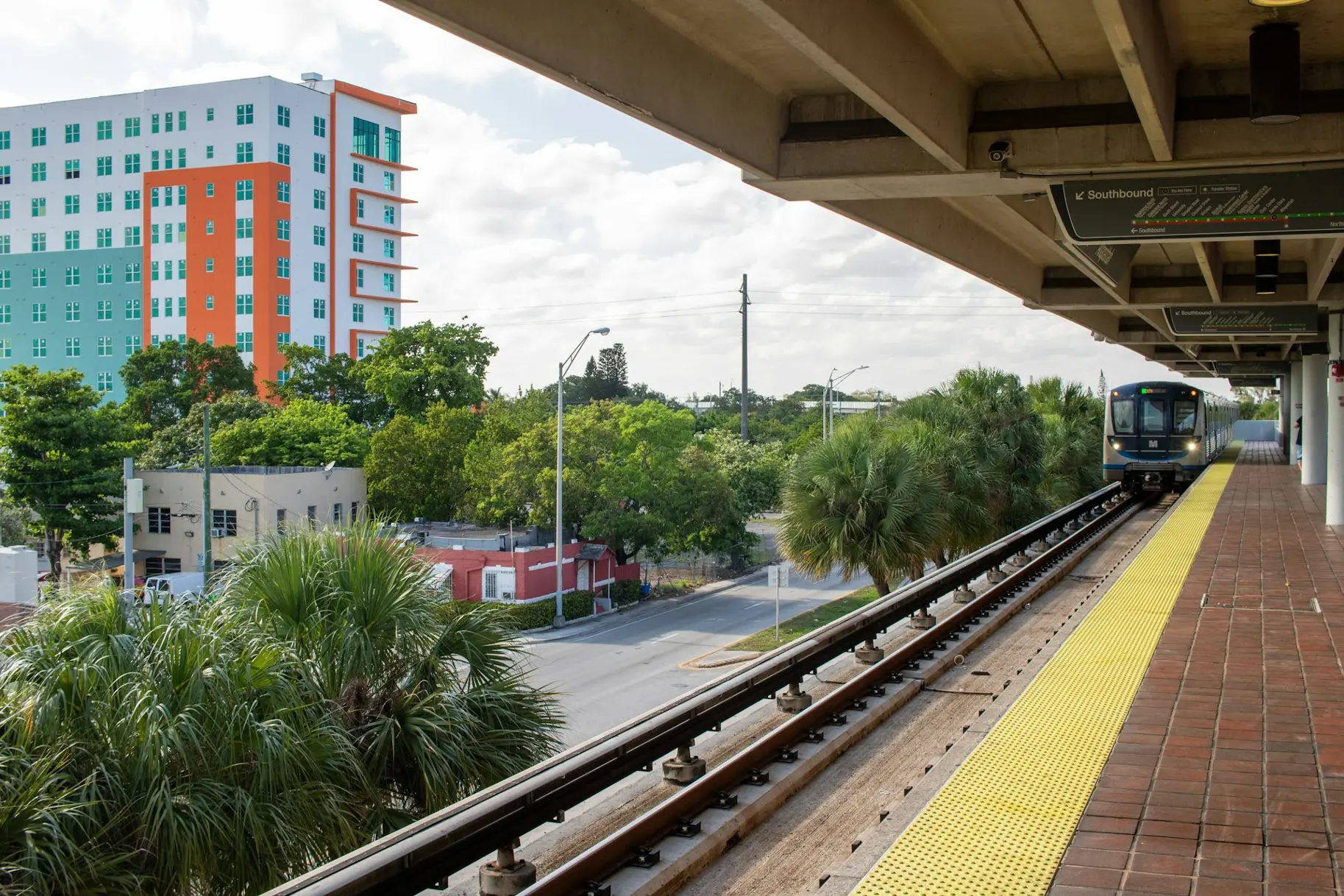 A train traveling down train tracks next to a tall building